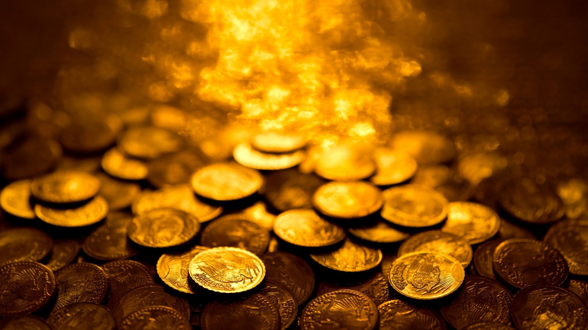 Pile of shiny golden coins scattering light
